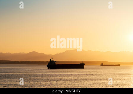 Zwei Fracht Containerschiffe auf Puget Sound neben dem Olympischen Berge bei Sonnenuntergang. Stockfoto