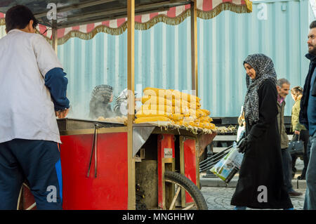 Istanbul, Türkei - 06 Januar, 2018: Der Mann, der den Verkauf von gekochtem und gebratenem Mais in touristischen Stadtteil Eminönü Istanbul, Türkei Stockfoto