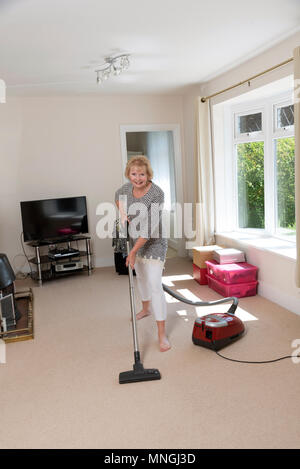 Home Umzüge, Frau mit einem Staubsauger den Teppich zu Hoover, bevor Sie aus dem Haus. Stockfoto