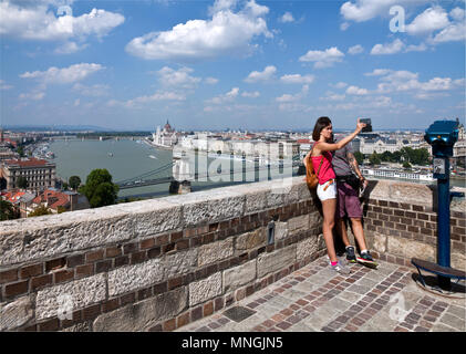 Paar ein selfie von der Terrasse aus auf die Hügel von Buda mit Pest, der berühmten ungarischen Parlament, und die Donau im Hintergrund. Stockfoto