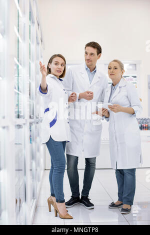 Ehrgeizige drei Apotheker diskutieren Medikament Stockfoto