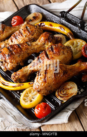 Fried Chicken drumstick mit Gemüse in einer Grillpfanne close-up auf einem Tisch. Vertikale Stockfoto