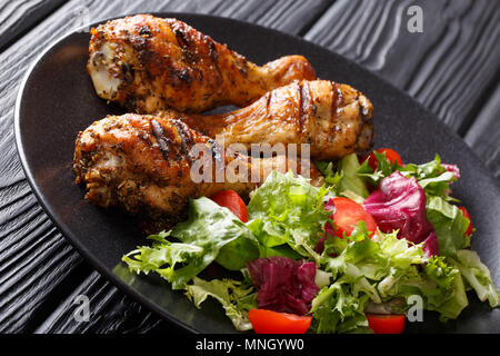 Grill serviert gegrillte Chicken Drumsticks und frisches Gemüse Salat closeup auf einem Teller. Horizontale Stockfoto