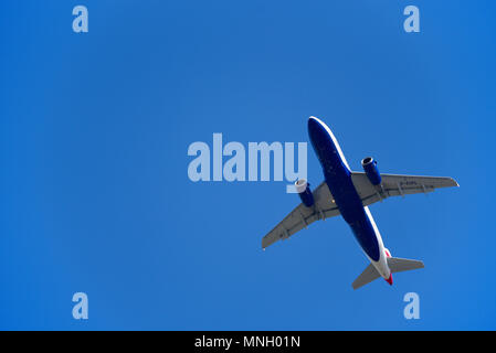 British Airways Jetflugzeug fliegt nach einer abgebrochenen Landung über dem Flughafen London Heathrow, UK im blauen Himmel. AIRBUS A319 G-EUPL Stockfoto