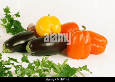 Paprika, Auberginen und Zweige Petersilie auf einem weißen Hintergrund. Stockfoto