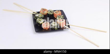 Sushi Set - verschiedene Arten von Maki Sushi auf schwarzem Teller. Stockfoto