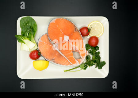 Roher Lachs Steak mit Gemüse auf Teller, Essen und Gemüse Konzept Stockfoto