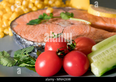 Frische tamato auf die gegrillten Fisch Lachs filet Teller, Essen und Gemüse Konzept Stockfoto