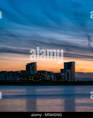 Leith Harbour, Edinburgh, Schottland, Großbritannien, 17. Mai 2018. Bunte moody Sonnenuntergang Himmel über dem Eingang Basin Harbor in Richtung der hohe Anstieg Apartment Gebäuden von Platin Punkt suchen, mit Reflexionen des Turms Bausteine im Wasser Stockfoto