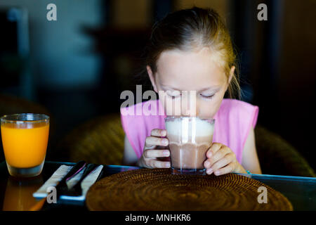 Adorable kleine Mädchen im Restaurant trinken heiße Schokolade Stockfoto