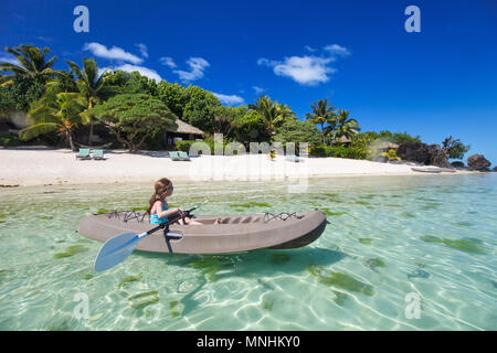 Kleines Mädchen mit Paddeln im Kajak im tropischen Ozean Wasser in den Sommerferien Stockfoto