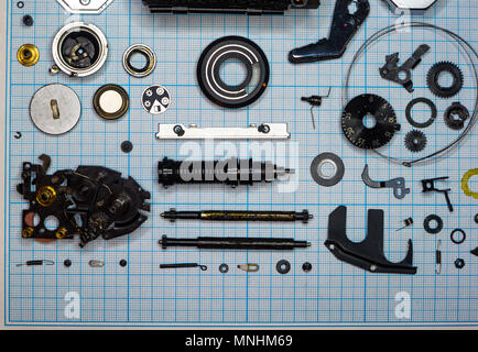Teile sind vollständig demontiert alten retro Film SLR Kamera auf Millimeterpapier, close-up Stockfoto