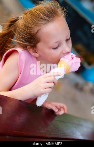 Adorable kleine Mädchen Eis essen in einer frischen Waffel Kegel in Café im Freien im Sommer Tag Stockfoto