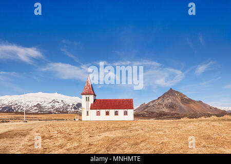 Weiße hölzerne Kirche in Hellnar, Halbinsel Snaefellsnes, West Island. Auf der linken Seite ist der Vulkan Snæfellsjökull, mit Schnee bedeckt, und auf der rechten Seite ist Stockfoto