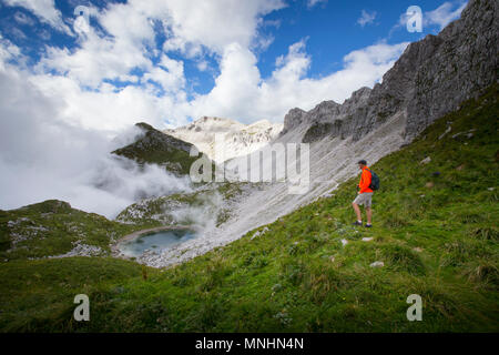 Wanderer mit Blick auf den See in der Nähe von Mount Krn, Slowenien. Diese alpine Wiese war Schlacht während des Ersten Weltkrieges. Stockfoto