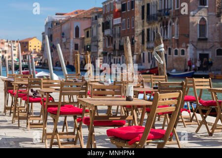 Street View eines Cafe Terrasse mit leeren Tischen und Stühlen in Venedig, Italien. Stockfoto