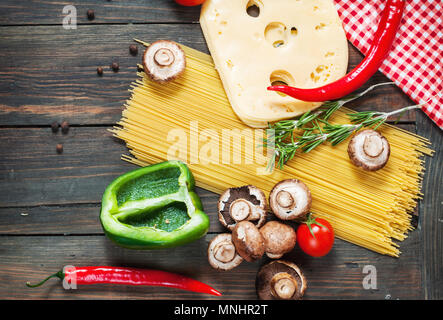 Pasta Zutaten. Cherry-Tomaten, Spaghetti Nudeln und Pilze auf dem Holztisch. Stockfoto
