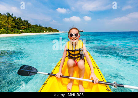 Kleines Mädchen mit Paddeln im Kajak im tropischen Ozean Wasser in den Sommerferien Stockfoto