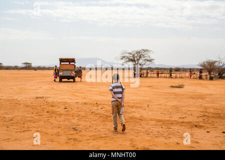 Adorable kleine Mädchen in Kenia Safari zu Fuß in Richtung des Fahrzeugs öffnen Stockfoto