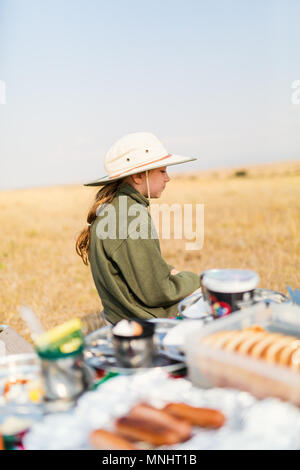 Adorable kleine Mädchen in Kenia Safari bush Frühstück genießen. Stockfoto