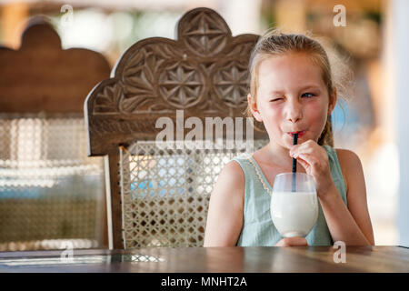 Portrait von entzückenden kleinen Mädchen trinken Milchshake Stockfoto