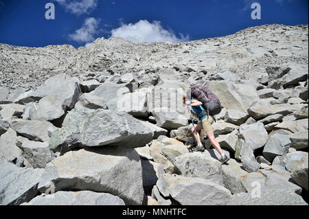 Backpackers Aufstieg durch steile Talus zu gefrorenen See Pass auf einer zwei-wöchigen Trek der Sierra Hohe Weg in Kings Canyon National Park in Kalifornien. Die 200 km Route etwa Parallels die beliebte John Muir Trail durch die Sierra Nevada von Kalifornien von Kings Canyon National Park, Yosemite National Park. Stockfoto