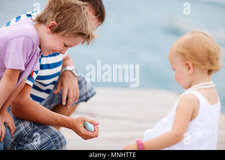 Vater, der seine Kinder einen Fisch. Fokus auf der Hand. Stockfoto