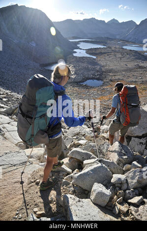 Backpackers Wanderung über Puppet Pass in die Marionette Seebecken auf einer zwei-wöchigen Trek der Sierra Hohe Weg in der John Muir Wildnis in Kalifornien. Die 200 km Route etwa Parallels die beliebte John Muir Trail durch die Sierra Nevada von Kalifornien von Kings Canyon National Park, Yosemite National Park. Stockfoto