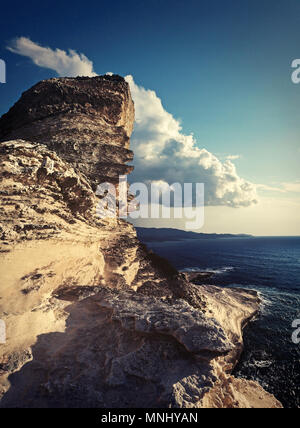 Die spektakulären weißen Küste von Bonifacio auf Korsika. Panoramablick auf das Meer und die Steilküste mit einer großen Wolke. Stockfoto