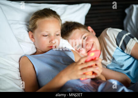 Kinder Bruder und Schwester spielen auf einem tragbaren Spiel Gerät oder Smartphone Stockfoto