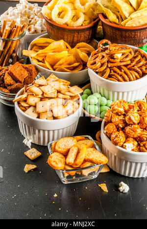 Variation verschiedener ungesunden Snacks Kekse, süßes Popcorn gesalzen, Tortillas, Muttern, Strohhalme, bretsels, zurück Tafel Platz kopieren Stockfoto