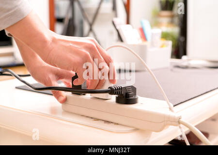 Frauen Hand den Netzstecker von der Stromversorgung Anschluss Stockfoto