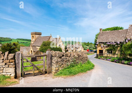 Snowshill, Cotswolds, England, UK. Wisteria Blumen auf einem Haus neben der Kirche in einem Cotswold Village. Stockfoto