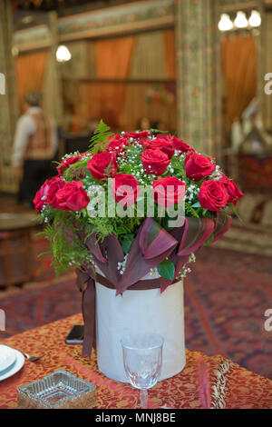 Rosen in einer Runde. Pfirsich Rosen in einer Runde. Rosen in einer Runde Box auf einem weißen Holz- Hintergrund. Romantisch rote Rosen in einer kleinen Geschenkbox weiß roun Stockfoto
