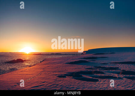 Der polar Sonnenuntergang Sonnenaufgang, während die extreme Expedition in die wernadsky Forschungsbasis erschossen wurde. Atemberaubenden Schneelandschaft der eisigen Antarktis Stockfoto