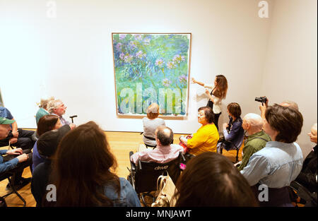 Besucher, die an ein Gemälde von Claude Monet, Agapanthus, Museum für Moderne Kunst (MoMA), New York City, USA Stockfoto