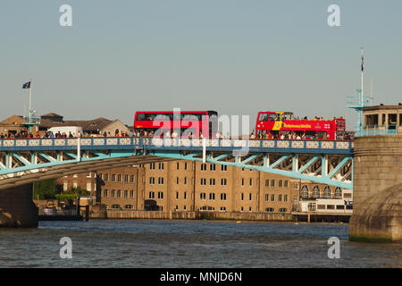 Ein Blick auf zwei Londoner Busse, eine oben offene und Fußgänger über die Tower Bridge, London mit Blick auf die Themse unten Stockfoto