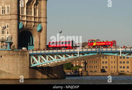 Ein Blick auf zwei Londoner Busse, eine oben offene und Fußgänger über die Tower Bridge, London mit Blick auf die Themse unten Stockfoto