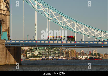 Eine Ansicht eines London Bus und Fußgänger über die Tower Bridge, London mit Blick auf die Themse und die Boote unten Stockfoto