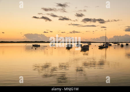 Verankert Segelboote und Wolken Reflexion bei Sonnenuntergang an der Estany des Peix marine Lagune in La Savina (Formentera, Balearen, Spanien) Stockfoto