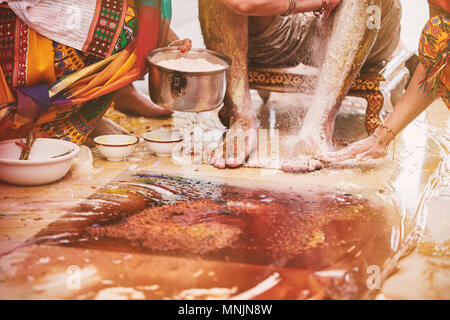 Der Bräutigam sitzen, während die Familie und Verwandten Mitgliedern einfügen Kurkuma Pulver (HALDI) Öl mit Milch vor dem Baden (snan) gemischt, traditionelle Ritual Stockfoto