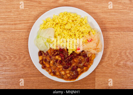 Rote Bohnen mit Curry Reis auf einem Holztisch Stockfoto