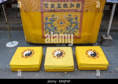 Drei Sätze gelber Kniepolster für Gebetszwecke vor einem taoistischen Tempel entlang der Telok Ayer Street. Singapur. Stockfoto