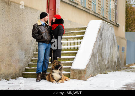 Glückliches Paar mit Hunden im Winter Wald. Schöne Momente im Urlaub. Stockfoto