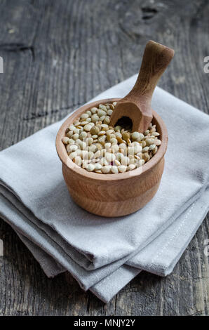 Brown Organic Getrocknete Linsen in eine Schüssel geben und auf alten rustikalen Holzmöbeln Hintergrund. Gesund vegan vegetarisch essen Konzept. Stockfoto