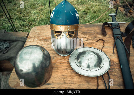 Mittelalterliche Szene. Mittelalterliche Ritter Attribute sind Helm, Kettenhemd, Schild Schild, Schwert, Hellebarde. Rekonstruktion des mittelalterlichen Lebens Stockfoto