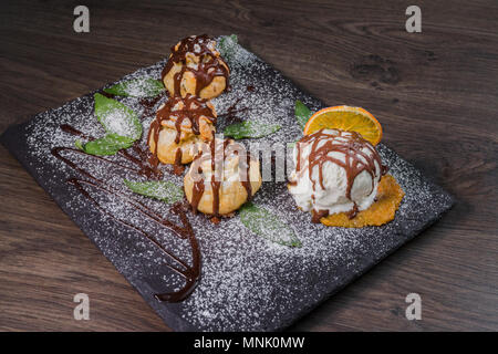 Eine Kugel Eis auf einem Stein mit einem orangefarbenen Stockfoto