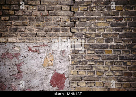 Ein rustikales und einsturzgefährdete Mauer von gestaffelt und gebrochene Backsteine mit einem Knacken und Reparatur. Stockfoto