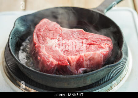 Raw Rib Eye Steak in der Pfanne Stockfoto