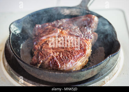 Rib Eye Steak gebraten auf Pflanzenöl auf Guss Stockfoto